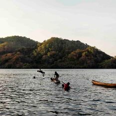 Children jumping off a boat in Indonesia.