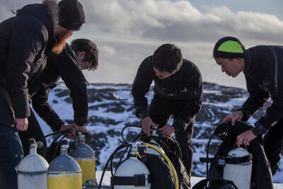 A group preparing to dive in dry suits