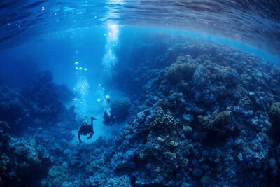 Two Nitrox divers swimming through a cave in the Red Sea.