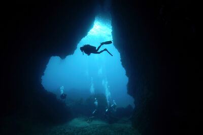 Divers with cave silhouette 