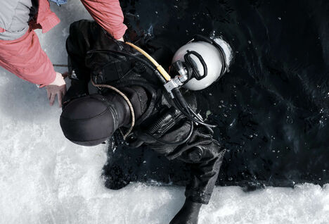 Person diving in a dry suit in icy water