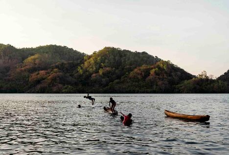 Children jumping off a boat in Indonesia.