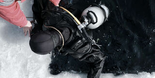 Person diving in a dry suit in icy water