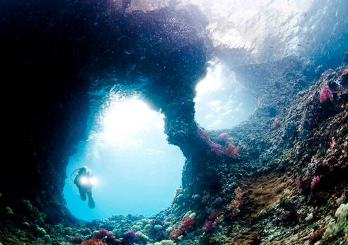 Deep sea diver in underwater cave.
